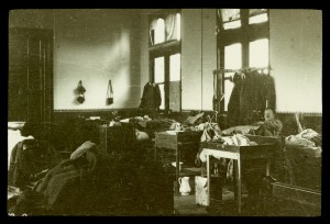 The ‘night nursery’ in a building known as the Red Asylum, Bailleul, Belgium, 1915. The building was used as a hospital by British forces from October 1914 until the evacuation of the town in April 1918. Serious cases, e.g. trephines, chest and abdominal wounds, amputations etc., were kept in one ward, which was often called 'the nursery' by medical and nursing staff as the casualties were all so helpless.